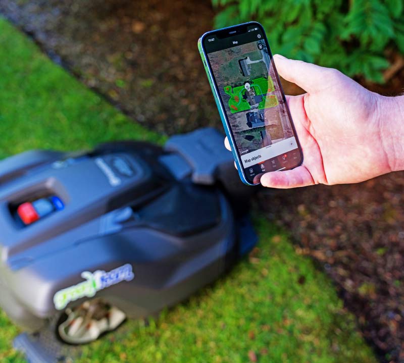 iphone with automower application and robotic mower in docking station